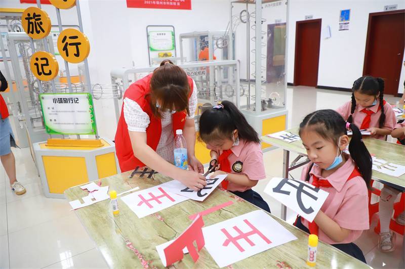 2021年7月10日，鄂州市科協(xié)組織落駕坪小學(xué)學(xué)生在鄂州市科技館開(kāi)展社會(huì)主義核心價(jià)值觀系列活動(dòng)，圖為開(kāi)展的紅色剪影圓夢(mèng)中華剪紙活動(dòng)，志愿者指導(dǎo)同學(xué)們.jpg