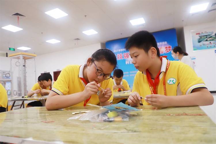 2021年7月9日鄂州市科協(xié)組織新民街小學學生在鄂州市科技館開展社會主義核心價值觀系列活動，圖為開展的科技創(chuàng)新圓夢中華科技小制作活動，孩子們正在相互配合制作蠕蟲機器人.jpg