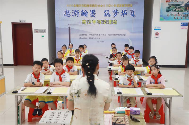 2021年7月10日，鄂州市科協(xié)組織蓮花小學(xué)學(xué)生在鄂州市科技館開(kāi)展社會(huì)主義核心價(jià)值觀系列活動(dòng)，圖為開(kāi)展的遨游翰墨筑夢(mèng)華夏書(shū)法活動(dòng)，老師講解握筆姿勢(shì)2.jpg