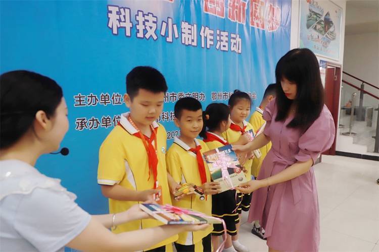 2021年7月9日鄂州市科協(xié)組織新民街小學學生在鄂州市科技館開展社會主義核心價值觀系列活動，圖為開展的科技創(chuàng)新圓夢中華科技小制作活動，科協(xié)王雨濛部長正在為優(yōu)先制作完成的學生頒發(fā)獎品.jpg