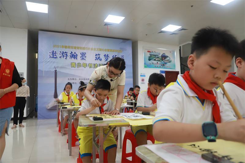 2021年7月10日，鄂州市科協(xié)組織蓮花小學(xué)學(xué)生在鄂州市科技館開(kāi)展社會(huì)主義核心價(jià)值觀系列活動(dòng)，圖為開(kāi)展的遨游翰墨筑夢(mèng)華夏書(shū)法活動(dòng)，老師指導(dǎo)學(xué)生.jpg